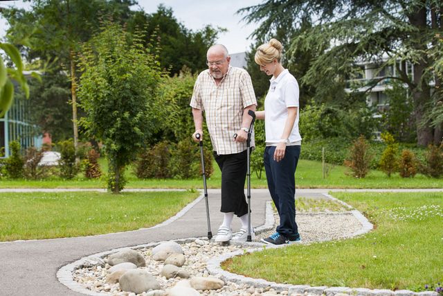 Patient und Physiotherapeutin laufen über Parcours im Park