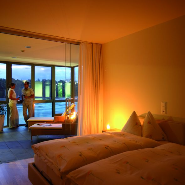 Paar steht im Wintergarten der Suite bei Abendstimmung